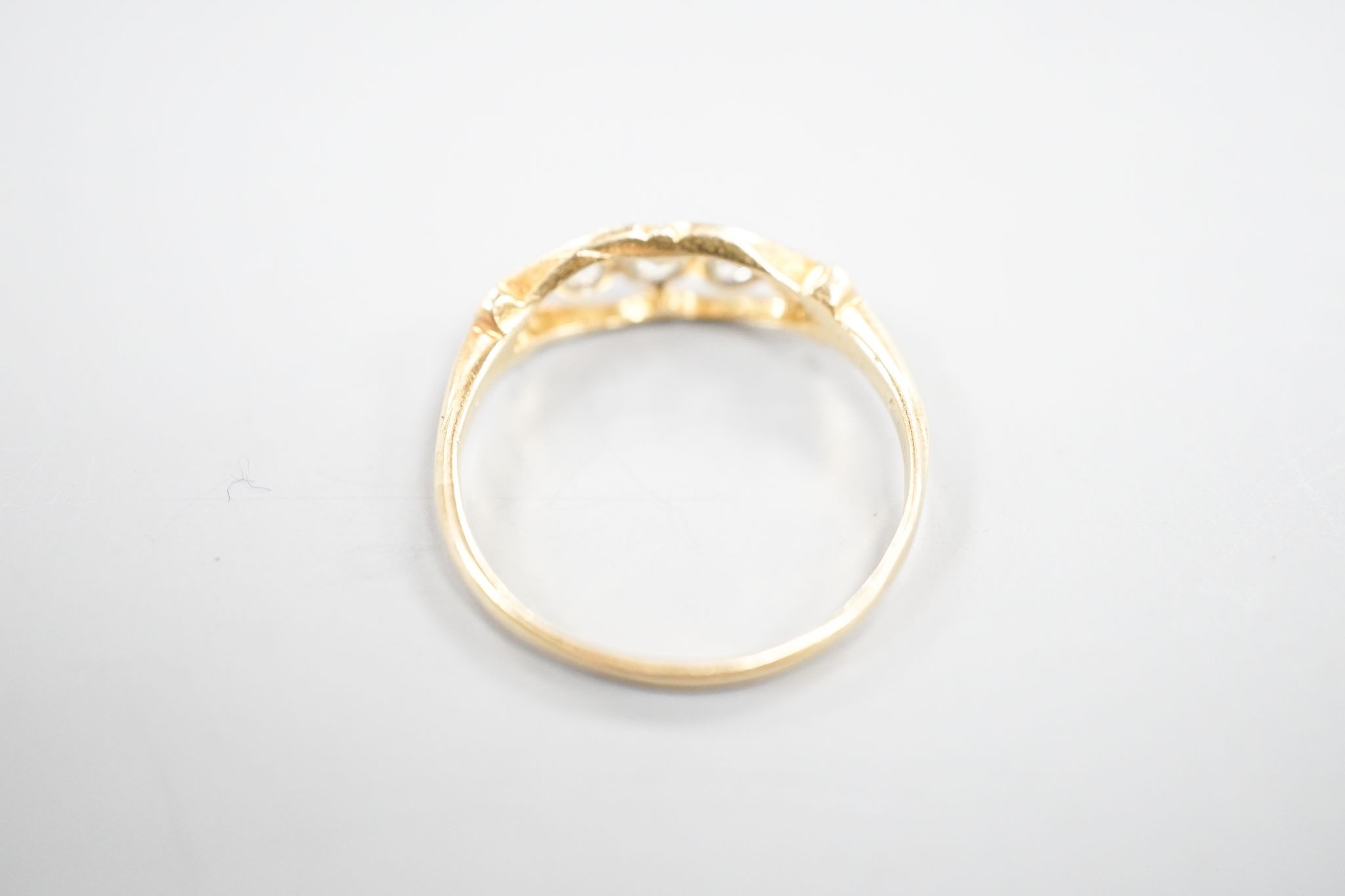 An 18ct and graduated five stone millegrain set diamond ring, size U/W, gross 2.6.